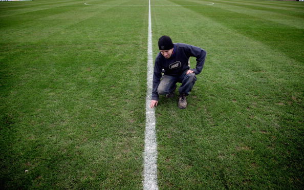 PAULTON, ENGLAND - NOVEMBER 06:  Groundsman Chris Filer examines the freshly painted lines on the pitch at Paulton Rovers Football Club on November 6, 2009 in Paulton, England.  Non-league Paulton Rovers are currently preparing for the single biggest day in their 128-year history as they face Norwich City in the FA Cup first round tomorrow. The Somerset village club - which beat Chippenham Town before being drawn against the League One club - normally has an attendance of 200, but will see capacity at the ground swell to 2500 and the match broadcasted live on television to an estimated audience of 2 million.  (Photo by Matt Cardy/Getty Images)